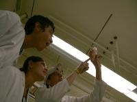 Trevor showing students engineered fluorescent bacteria.
